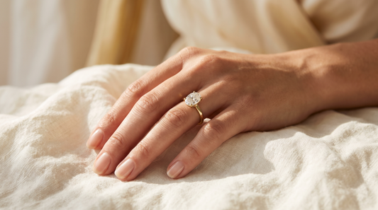 Mano de mujer con anillo de compromiso solitario en oro amarillo con diamante oval - Galería de Joyas Costa Rica