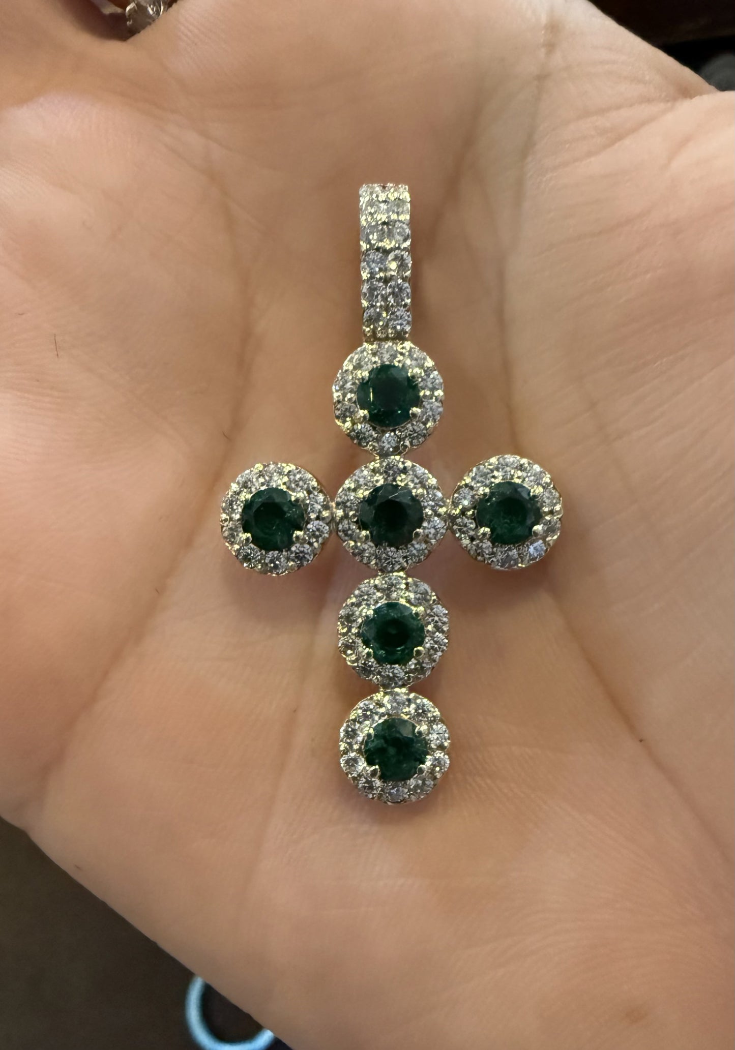 Cruz en oro con piedras verdes y halos de zirconias