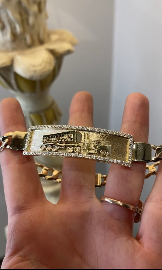 Pulso placa con grabado de camión y zirconias en oro